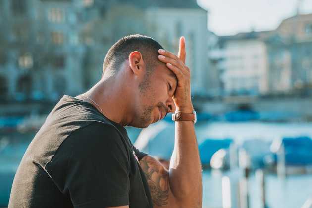 Photo of person with palm on forehead visibly stressed